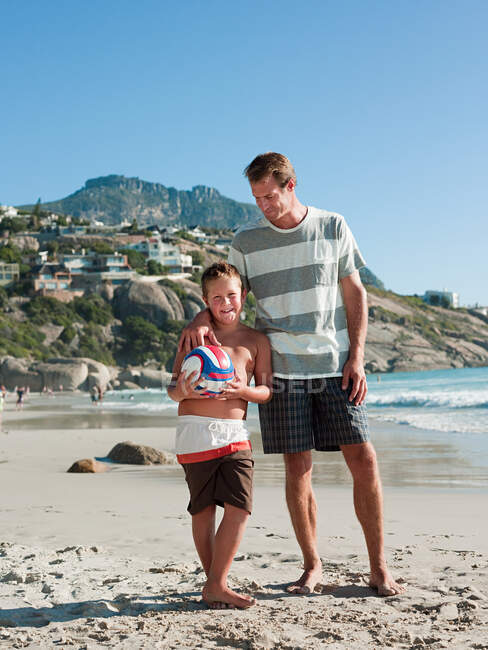 Père et fils sur une plage avec ballon — Photo de stock
