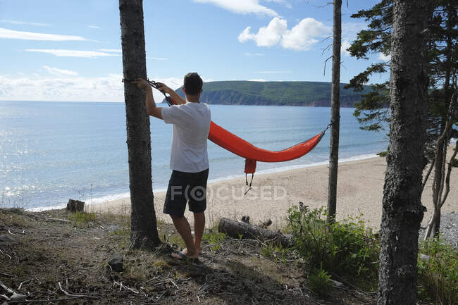 Man preparing hammock, Ingonish, Cape Breton, Nova Scotia, Canada — Stock Photo