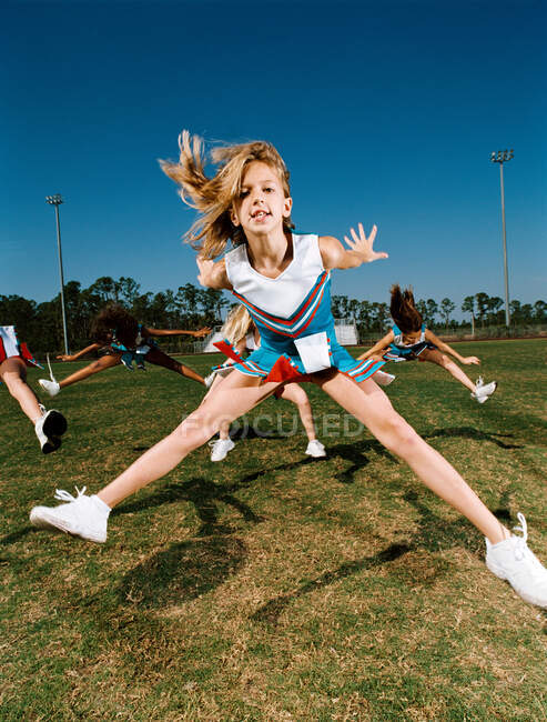 Cheerleaders performing dance routine on sports field — Stock Photo
