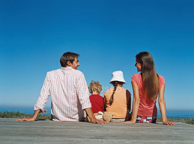 Famiglia seduta su un ponte — Foto stock