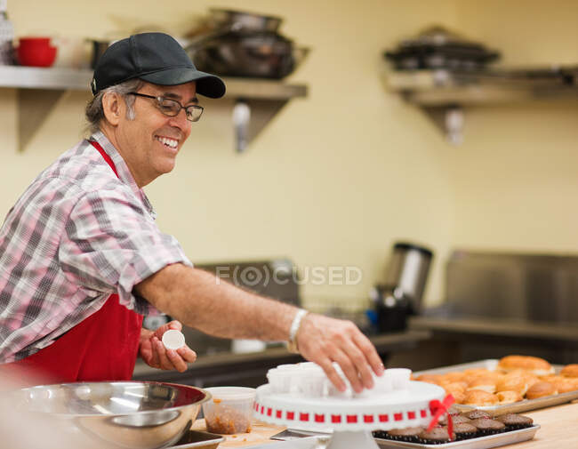Mature baker preparing food in kitchen — Stock Photo