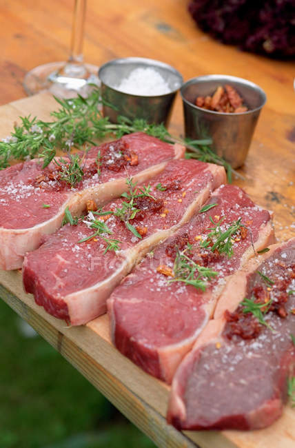 Grilling steaks with herbs — Stock Photo