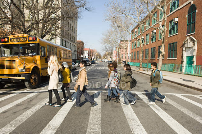 Teacher and pupils crossing road — Stock Photo