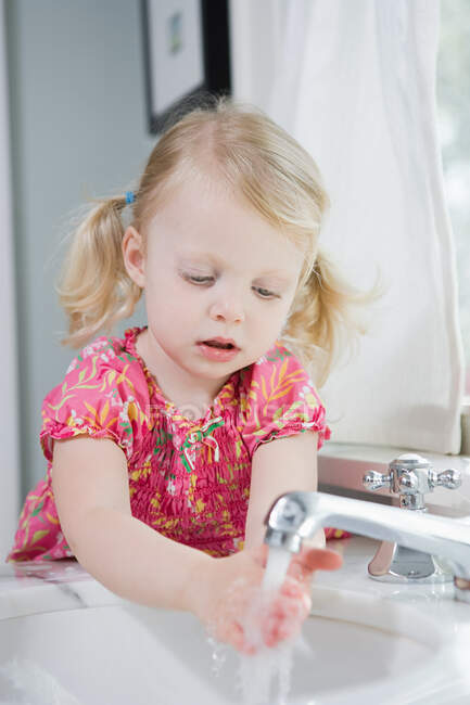 Девушка моет руки — стоковое фото