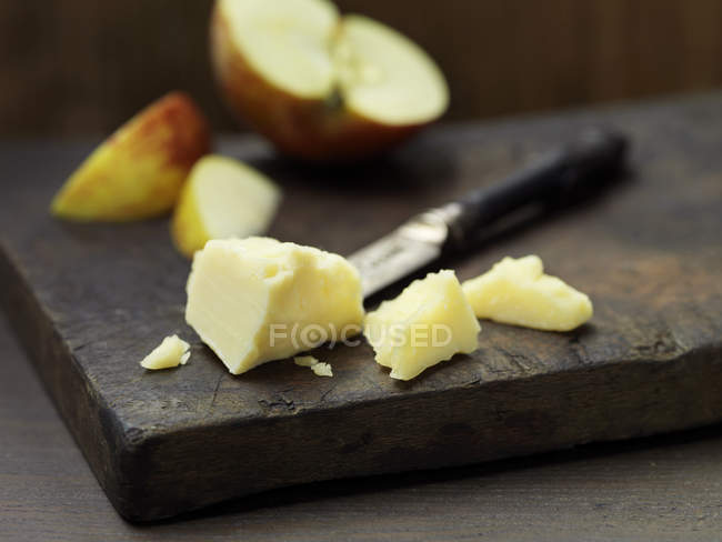 Mature cheddar cheese with apple slices on wood — Stock Photo