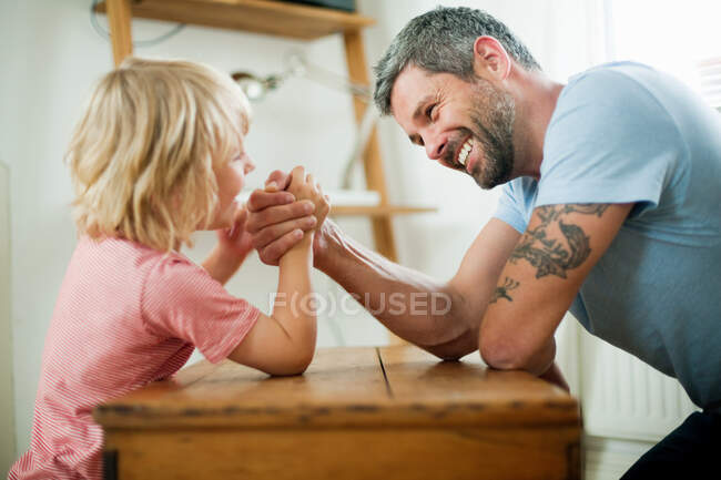 Mid adult man arm wrestling with son — Stock Photo