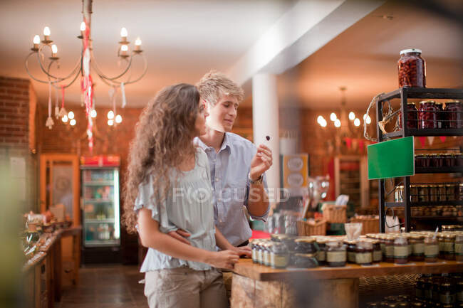 Couple tasting olives in grocery — Stock Photo