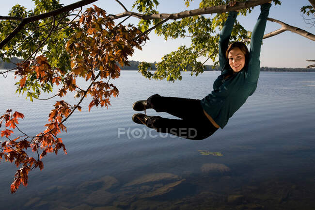 Mulher balançando de árvore — Fotografia de Stock