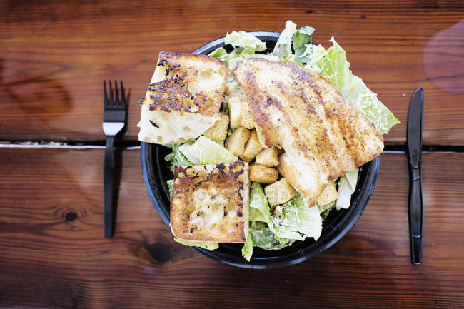 Prato de peixe de golfinho Mahi-mahi com legumes e croutons na mesa de madeira — Fotografia de Stock