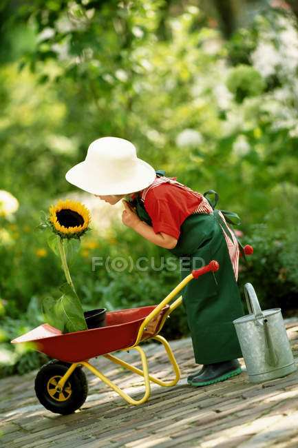 Mädchen mit Sonnenblume im Garten — Stockfoto