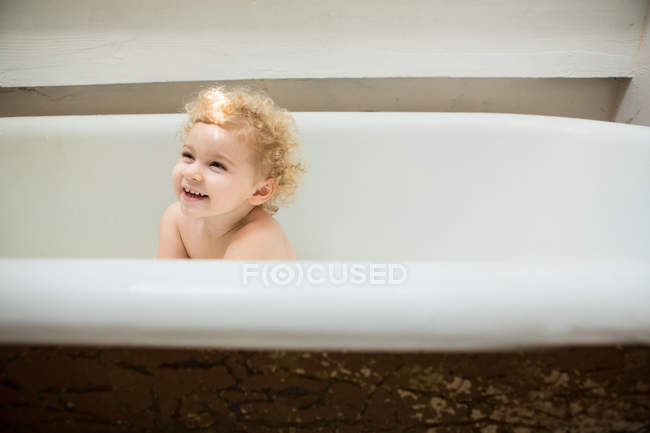Sorridente bambino seduto nella vasca da bagno — Foto stock