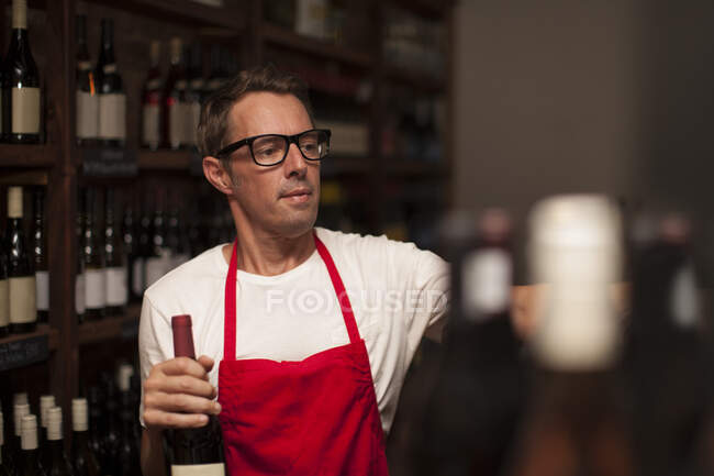 Cape Town, South Africa, young male wine shopkeeper in storeroom full of winery — Stock Photo