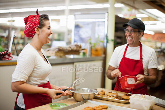 Mujer joven y hombre riendo en la cocina comercial - foto de stock