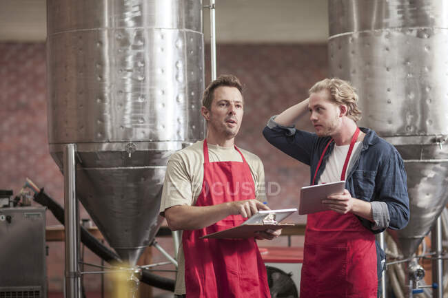 Cape Town, South Africa, two males discussing with one another  in brewery room — Stock Photo