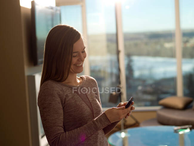 Mujer sonriente usando el teléfono celular - foto de stock