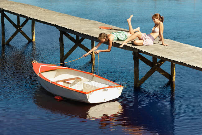 Teenage girls relaxing on jetty — Stock Photo