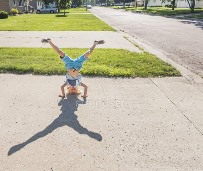 Junge macht Handstand auf Auffahrt — Stockfoto