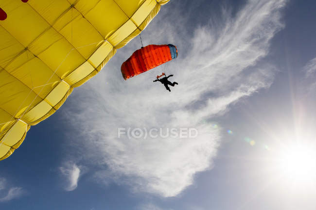 Parachutiste féminin direction parachute jaune — Photo de stock