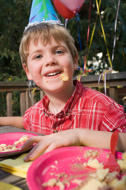 Хлопчик з тортами на обличчі — стокове фото