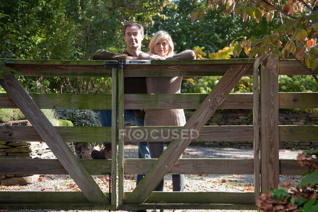 Paar lehnt an Holztor — Stockfoto