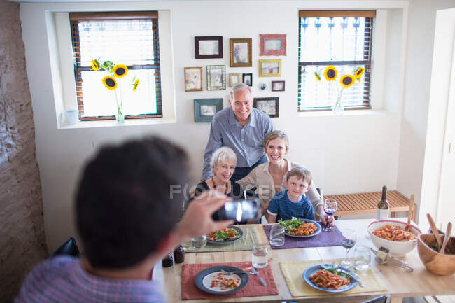 Чоловік фотографує сім'ю під час їжі — стокове фото