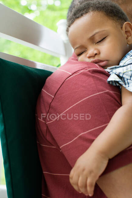 A grandfather holding his sleeping grandson — Stock Photo