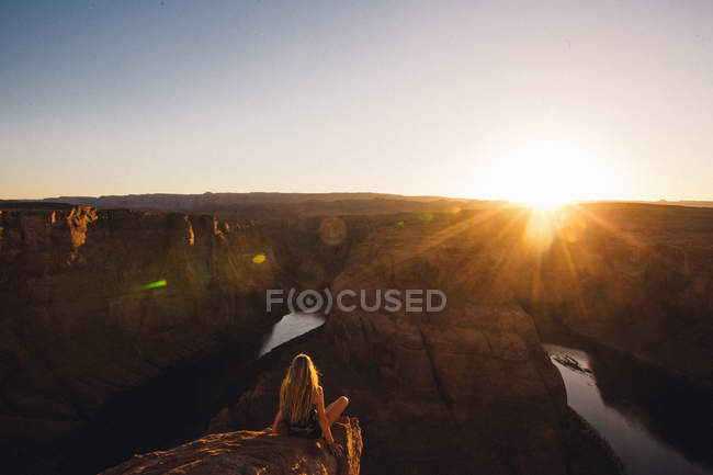 Женщина расслабляется и наслаждается видом, Подкова изгиба, Пейдж, Аризона, США — стоковое фото