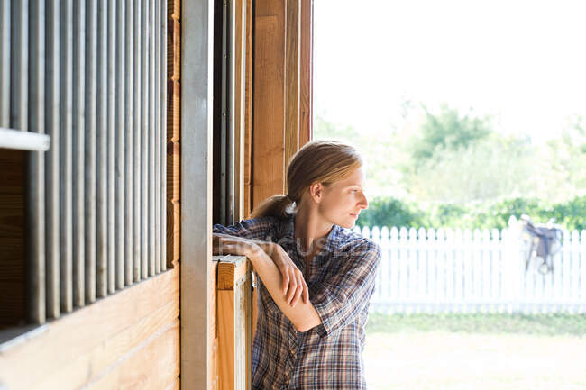 Donna adulta in stalla, distogliendo lo sguardo — Foto stock