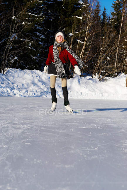 Une adolescente souriante patinage sur glace — Photo de stock