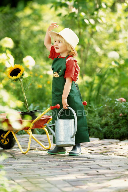 Девушка с подсолнухом в саду — стоковое фото