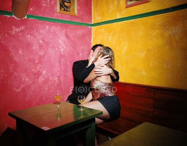 Casal beijando no canto do bar — Fotografia de Stock