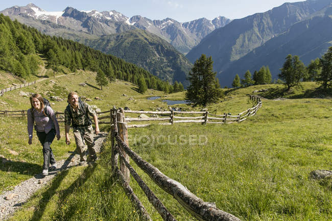 Senderismo joven pareja camino arriba, Karthaus, Val Senales, Tirol del Sur, Italia - foto de stock