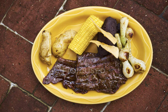Overhead view of plate with meat and corn on the cob,  Antigua, Guatemala — Stock Photo