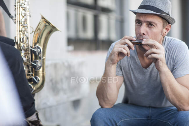 Kapstadt, Südafrika, Mann mit Hut spielt Mundharmonika — Stockfoto