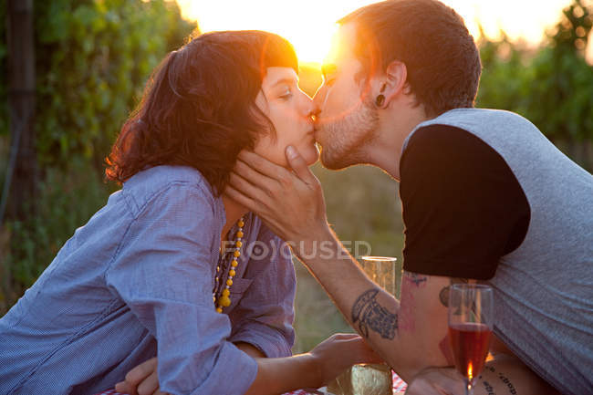 Couple embrasser au coucher du soleil — Photo de stock