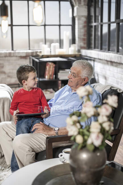 Дедушка и внук используют цифровой планшет дома — стоковое фото