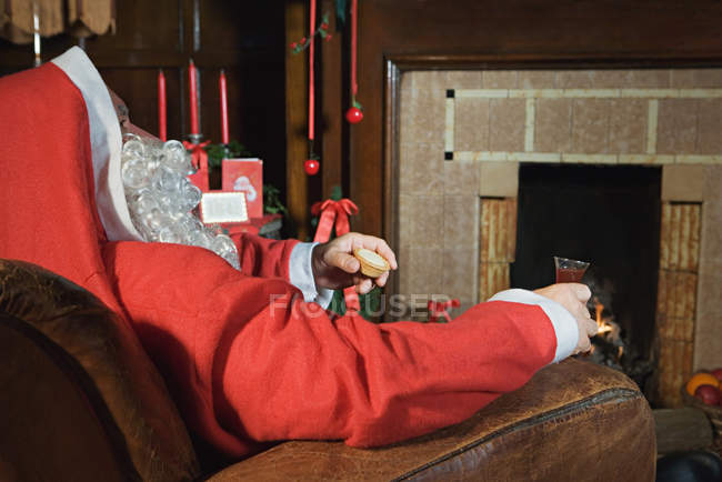 Santa claus resting by the fireplace — Stock Photo