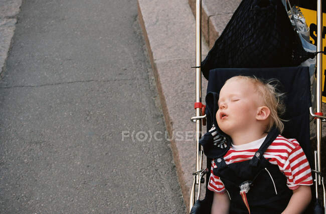 Bebé dormido en un cochecito - foto de stock