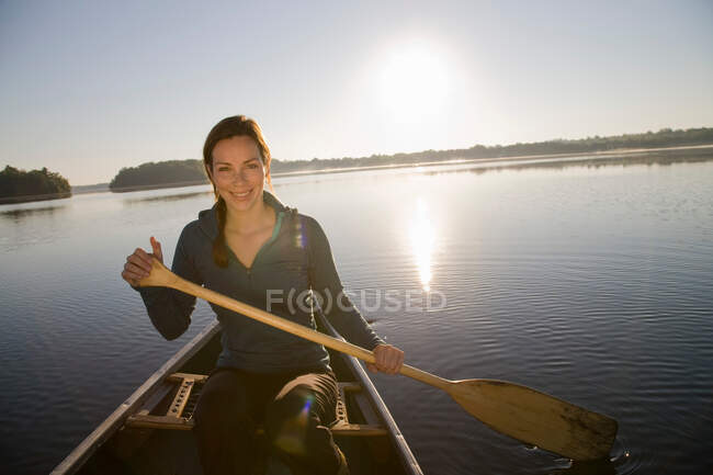 Woman canoeing in morning light — Stock Photo