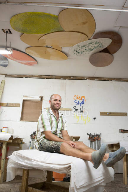 Porträt eines Mannes, der in einer Skimboard-Werkstatt sitzt — Stockfoto