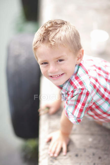 Ritratto di giovane ragazzo appoggiato alla parete del molo — Foto stock