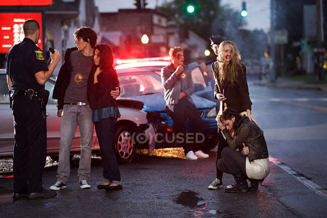 Молодые люди и полицейский на месте ДТП — стоковое фото
