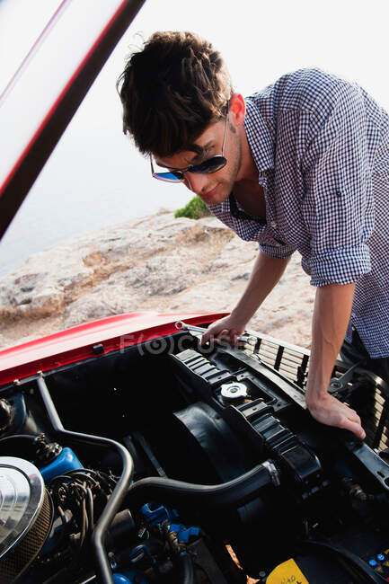Портрет человека, смотрящего на двигатель автомобиля — стоковое фото