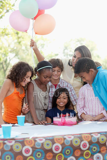 Crianças na festa de aniversário com bolo de aniversário — Fotografia de Stock