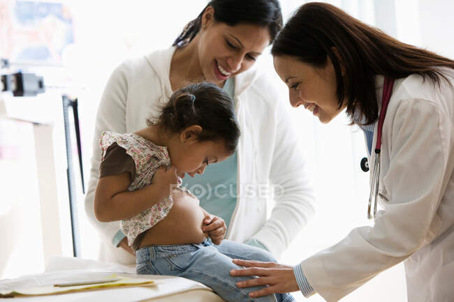 Médico examinando chica joven en la oficina - foto de stock