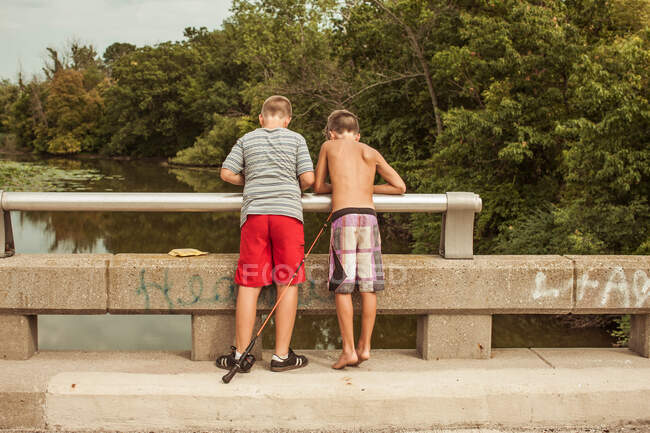Jungen auf Brücke mit Angelrute — Stockfoto