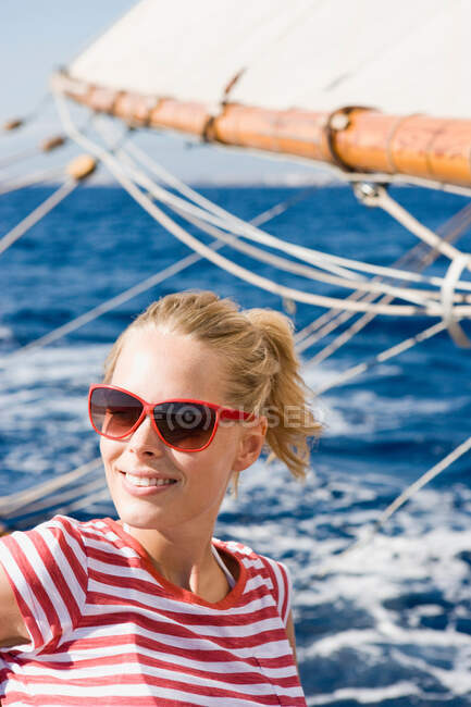 Mujer sentada en un velero - foto de stock