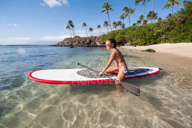 Jovem mulher paddleboarding no oceano — Fotografia de Stock