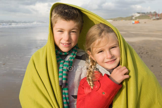Дети в одеяле у моря — стоковое фото