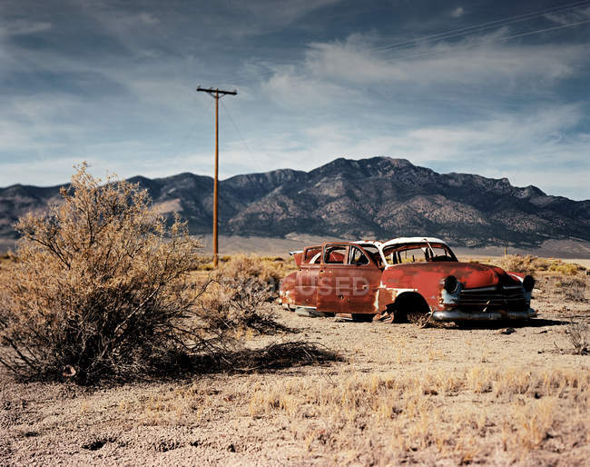 Abandoned retro car in fry land near mountains — Stock Photo
